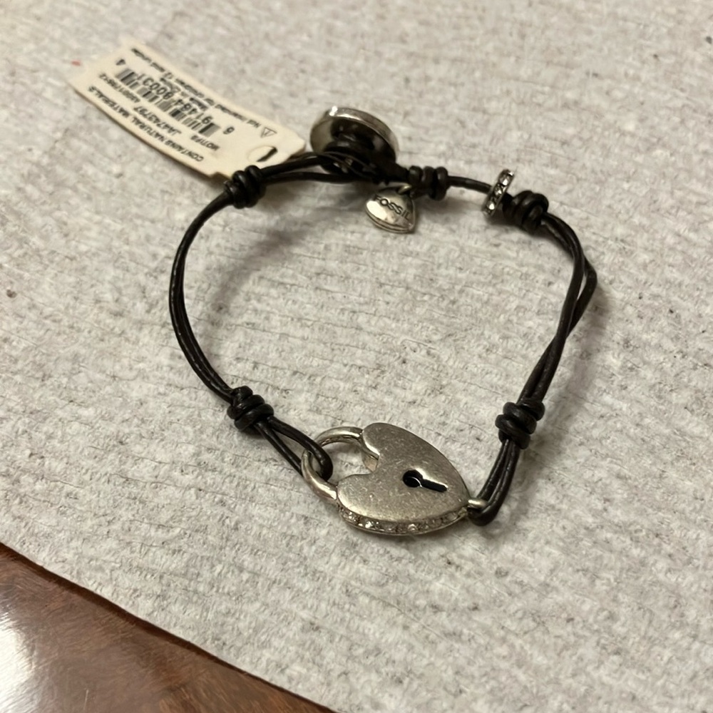 FOSSIL BRACELETT WITH HEART LOCK. BLACK CORD AND SILVER TRINKET. NWT